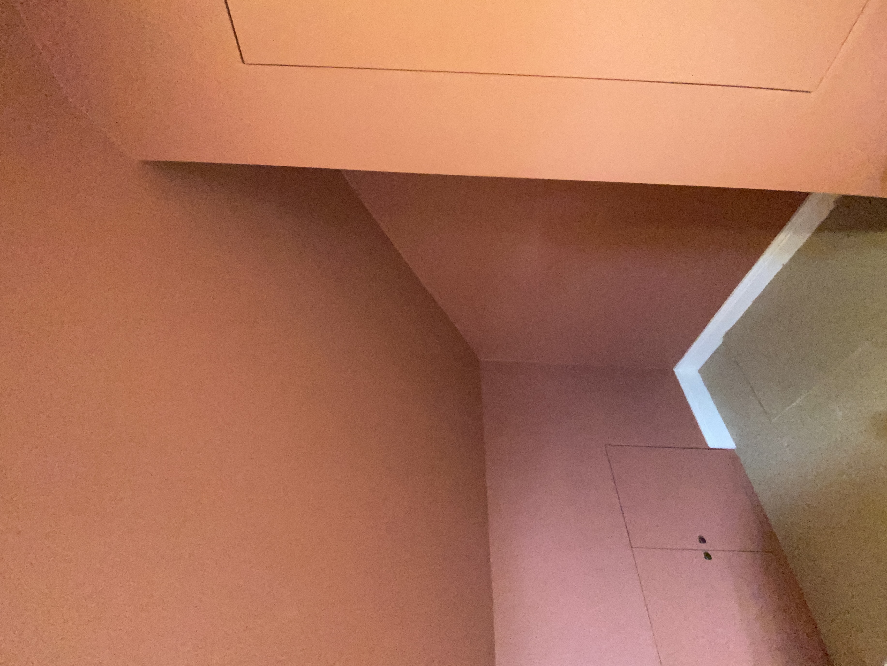 Vaulted terracotta ceiling in a loft room, lit by a skylight and downlights